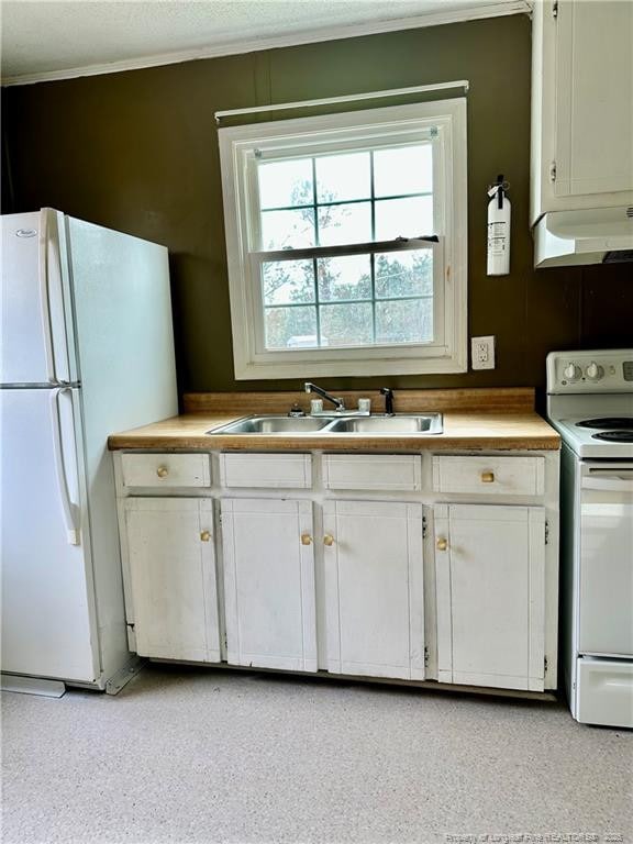 kitchen featuring white appliances, sink, and white cabinets