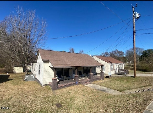 view of front of home featuring a front lawn, a porch, and a shingled roof