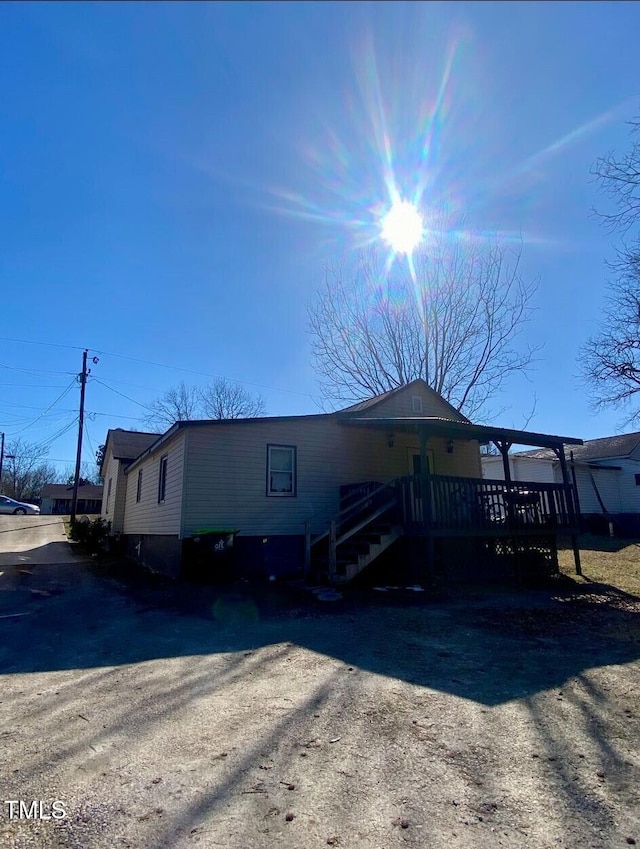 view of front of house featuring driveway and a deck