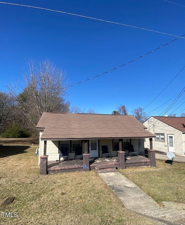 view of front of home with covered porch and a front lawn