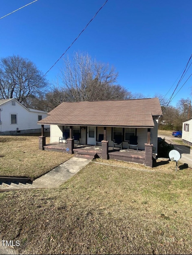 view of front of house with covered porch and a front lawn