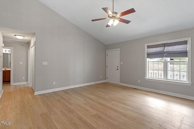 unfurnished room with light wood-type flooring, baseboards, high vaulted ceiling, and a ceiling fan