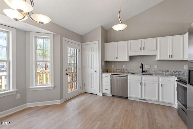 kitchen with light wood-style flooring, a sink, light stone counters, white cabinetry, and stainless steel appliances