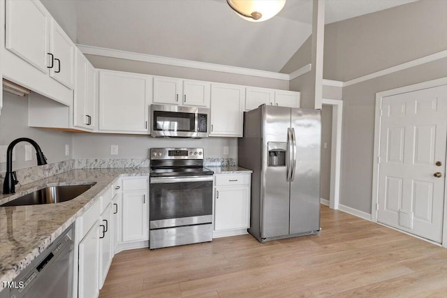 kitchen with a sink, lofted ceiling, appliances with stainless steel finishes, and white cabinetry