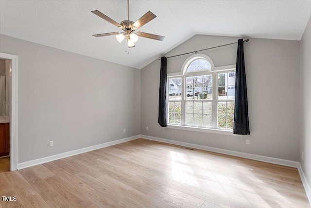 spare room with light wood-style flooring, a ceiling fan, baseboards, and a textured ceiling