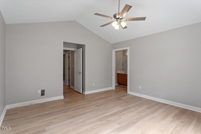 unfurnished bedroom with ensuite bathroom, baseboards, light wood-type flooring, and lofted ceiling