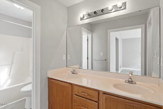 full bath with a sink, toilet,  shower combination, and double vanity