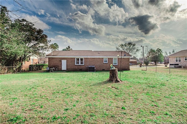 back of property with central AC unit and a yard