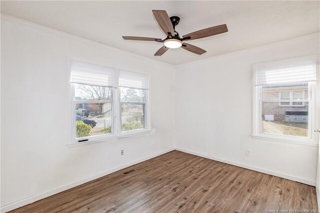 empty room featuring hardwood / wood-style flooring, ceiling fan, and crown molding