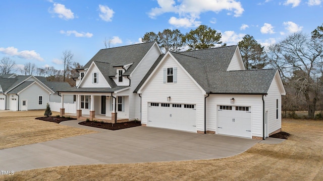 view of front of property with a garage, a front yard, and covered porch