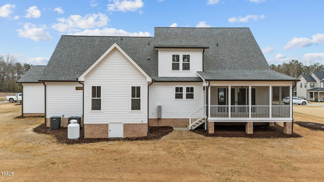 rear view of house featuring cooling unit and a sunroom