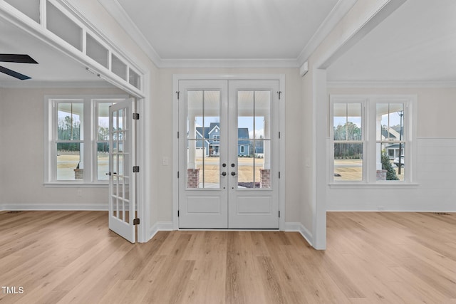 entrance foyer with french doors, crown molding, and light hardwood / wood-style floors