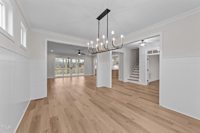 unfurnished dining area featuring ceiling fan with notable chandelier, light hardwood / wood-style flooring, and ornamental molding