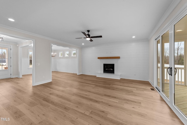 unfurnished living room with ornamental molding, a healthy amount of sunlight, and light wood-type flooring