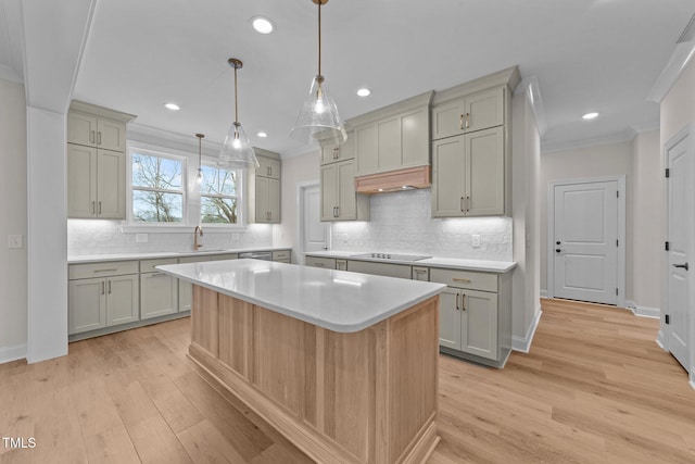 kitchen featuring a center island, black electric cooktop, ornamental molding, gray cabinets, and custom range hood