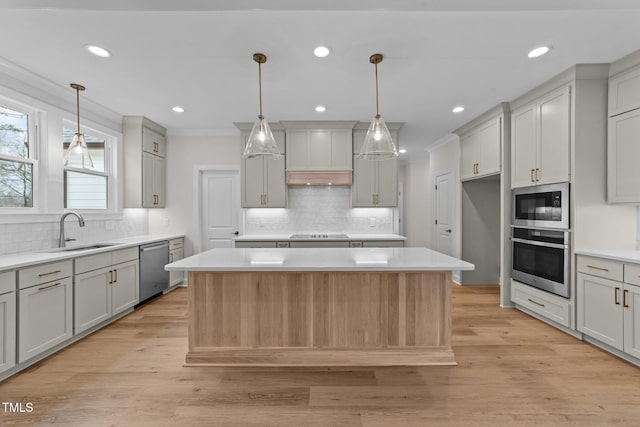 kitchen featuring stainless steel appliances, a center island, sink, and gray cabinetry