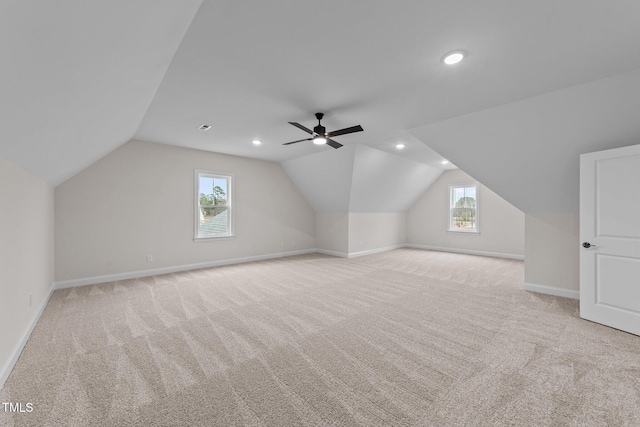 bonus room featuring lofted ceiling, light colored carpet, and a healthy amount of sunlight