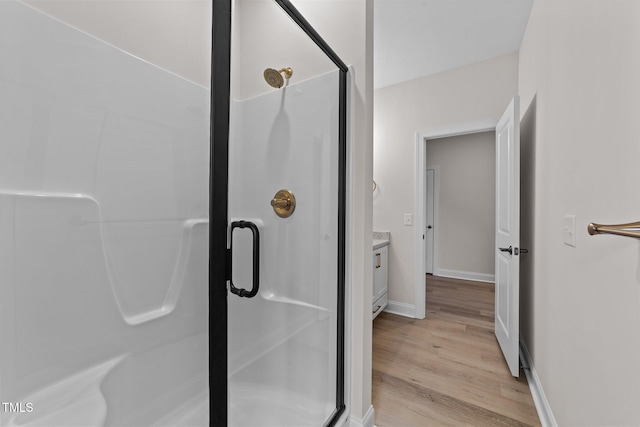 bathroom with vanity, hardwood / wood-style flooring, and walk in shower