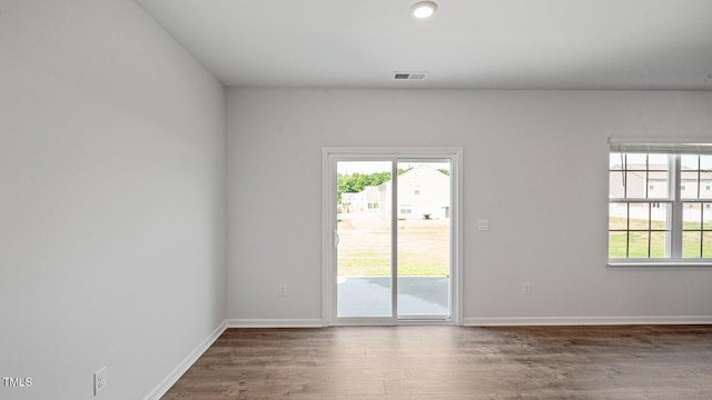 empty room featuring a healthy amount of sunlight and wood-type flooring