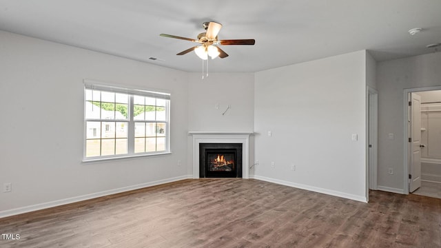 unfurnished living room with ceiling fan and wood-type flooring