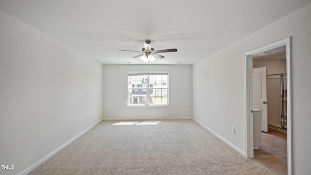 spare room with ceiling fan and light colored carpet