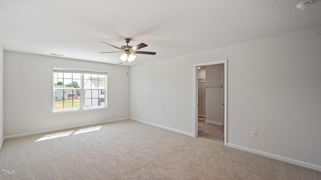 carpeted spare room featuring ceiling fan