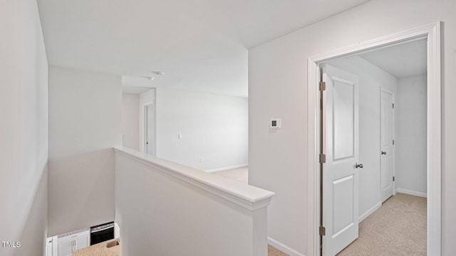 hallway featuring light colored carpet