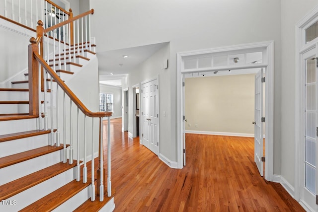 entrance foyer featuring stairway, baseboards, and wood finished floors