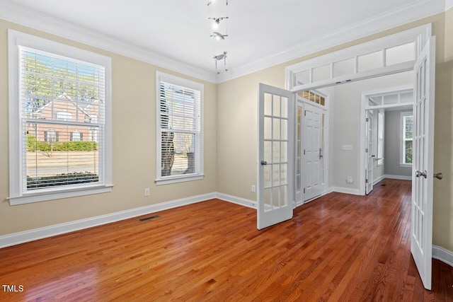 spare room featuring visible vents, wood finished floors, crown molding, and french doors