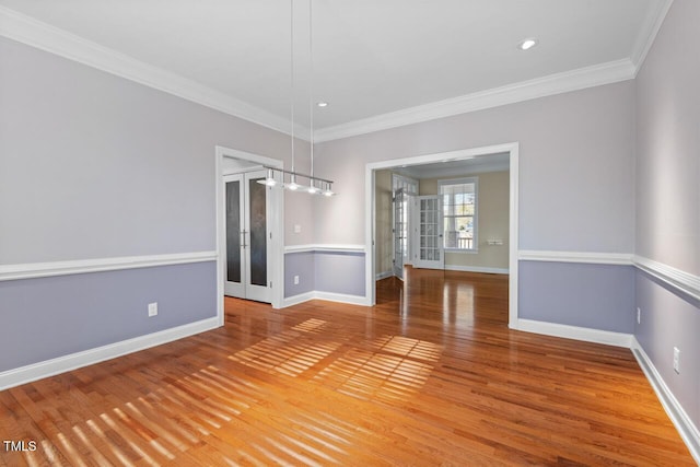 unfurnished dining area featuring light wood-style floors, baseboards, french doors, and ornamental molding