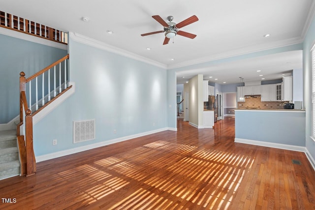 unfurnished living room featuring dark wood-style floors, baseboards, stairs, and visible vents