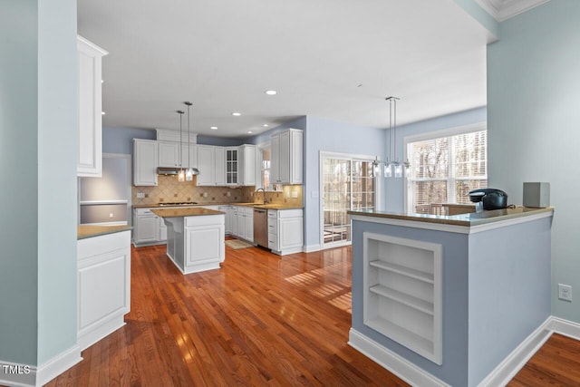 kitchen featuring dark wood-style flooring, a kitchen island, white cabinets, stainless steel dishwasher, and open shelves