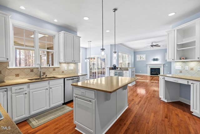 kitchen with white cabinets, a sink, ceiling fan, wood finished floors, and dishwasher