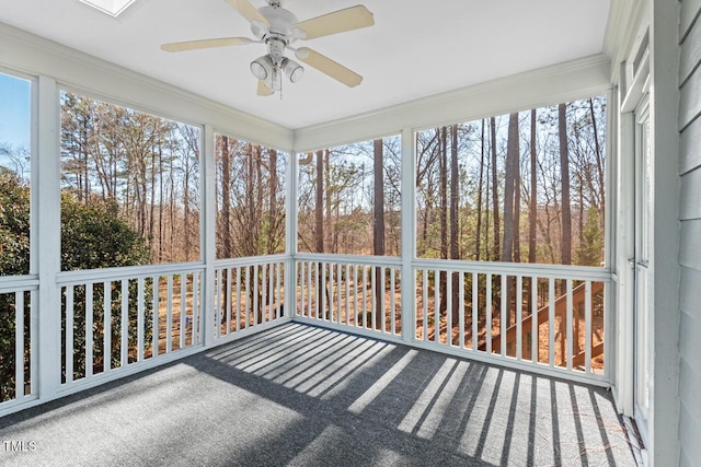 unfurnished sunroom featuring ceiling fan