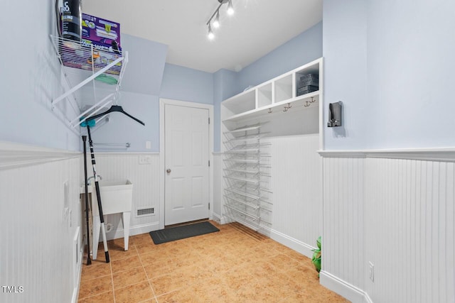 mudroom with rail lighting and wainscoting