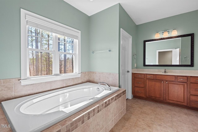 full bathroom featuring tile patterned flooring, a garden tub, and vanity