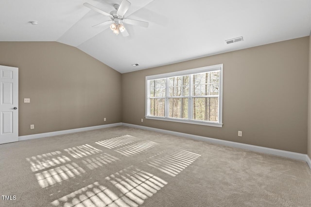 empty room with visible vents, vaulted ceiling, and baseboards