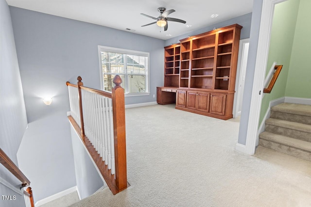 hallway with visible vents, baseboards, light colored carpet, stairs, and an upstairs landing