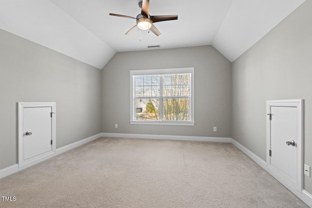 bonus room featuring light colored carpet, visible vents, vaulted ceiling, and baseboards