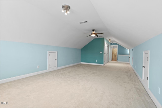 additional living space featuring ceiling fan, light carpet, visible vents, baseboards, and vaulted ceiling