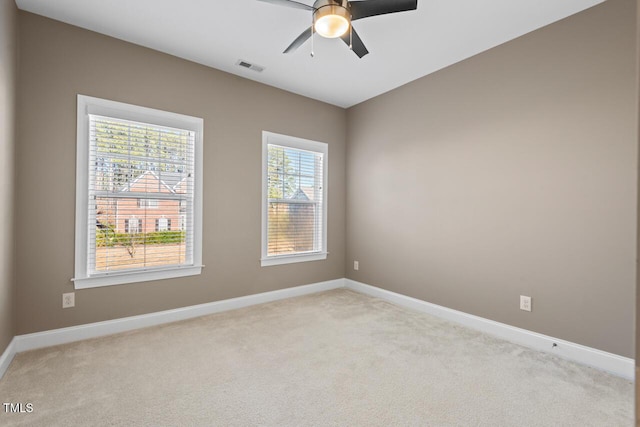 unfurnished room featuring light carpet, baseboards, visible vents, and ceiling fan