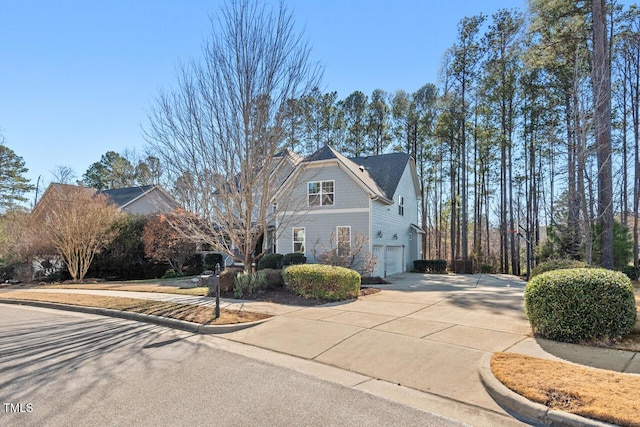 view of front of home with concrete driveway and an attached garage