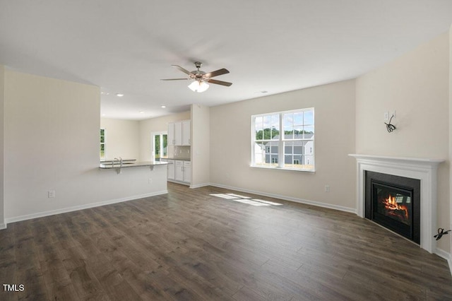 unfurnished living room with dark wood-type flooring and ceiling fan