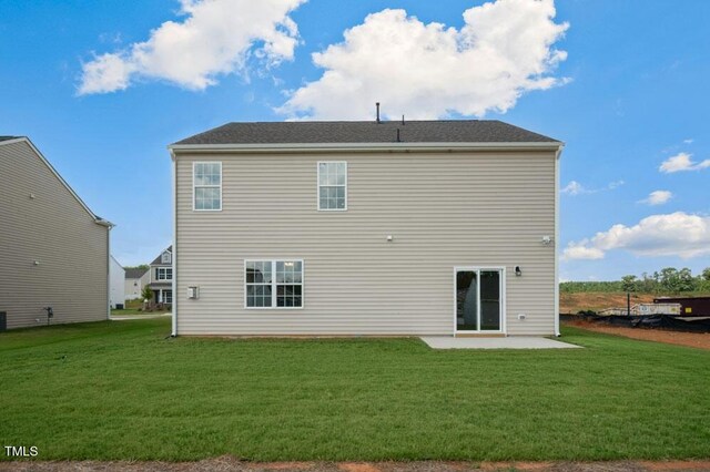 rear view of property with a yard and a patio area