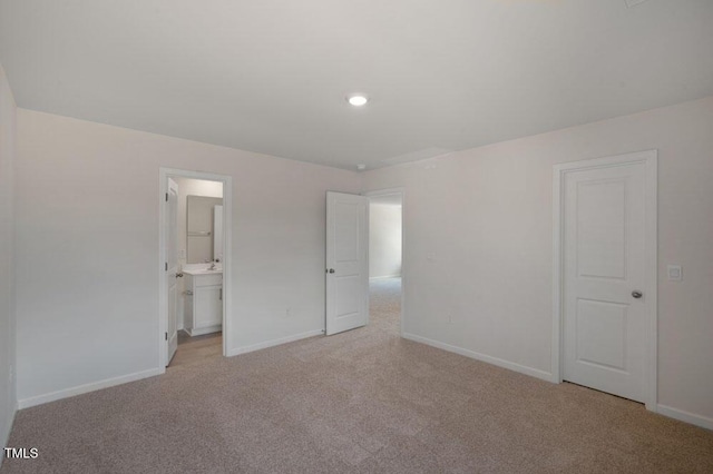 unfurnished bedroom with connected bathroom and light colored carpet