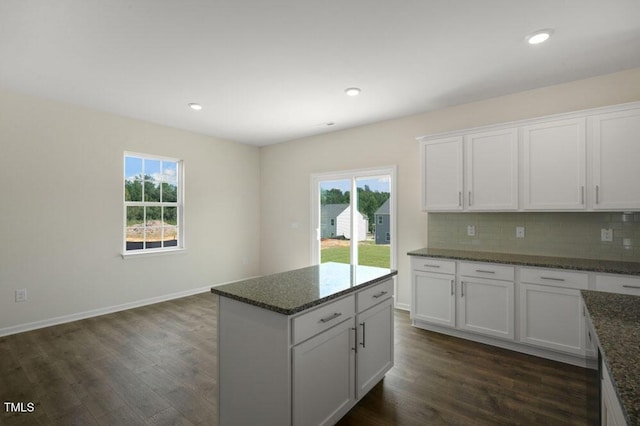 kitchen featuring white cabinetry, backsplash, dark wood-type flooring, and dark stone counters