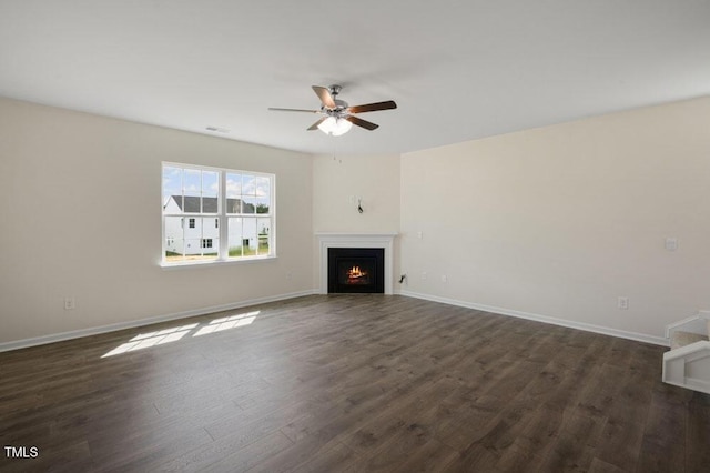 unfurnished living room featuring dark hardwood / wood-style floors and ceiling fan