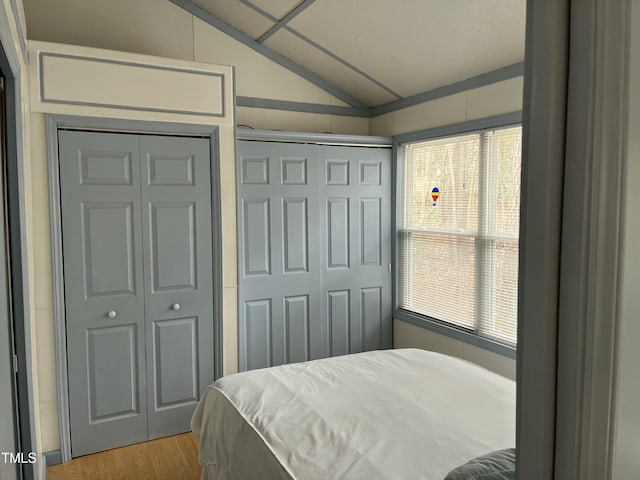 bedroom featuring lofted ceiling and light hardwood / wood-style floors