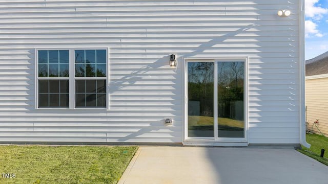 view of exterior entry with a patio area