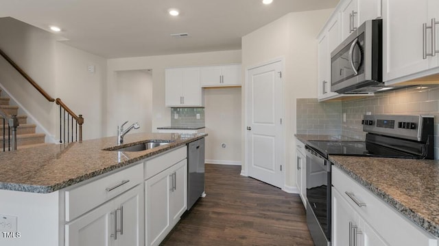 kitchen with appliances with stainless steel finishes, sink, an island with sink, and white cabinets